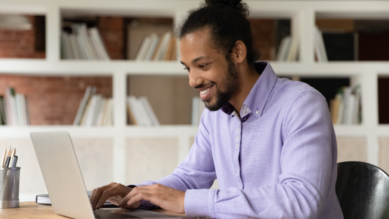 Man smiling in front of laptop