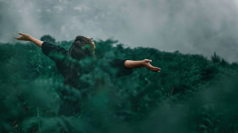 Someone standing in a field being free