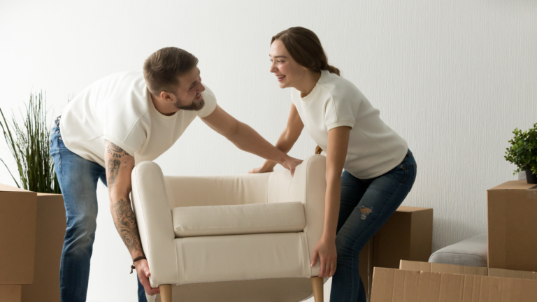 Two people moving a white couch