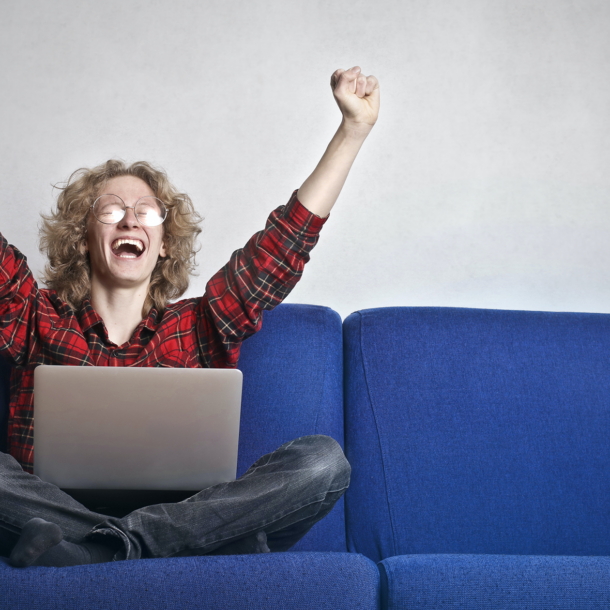 Man sitting in front of laptop being happy