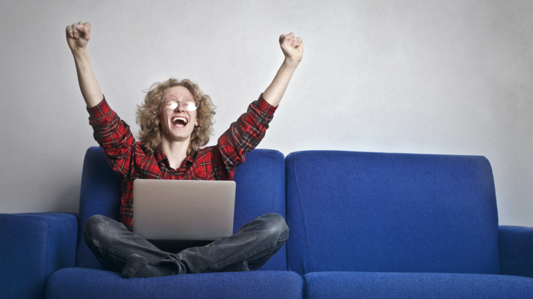 Man sitting in front of laptop being happy