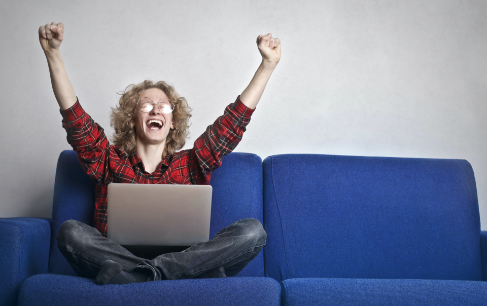 Man sitting in front of laptop being happy
